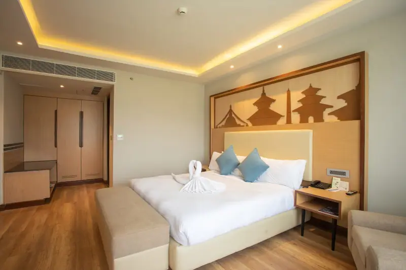 Guest room with a double bed and seating at Pokhara Grande