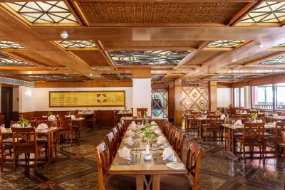 Pokhara Grande - Photo 2 Dining room with wooden tables and a carved ceiling at Pokhara Grande